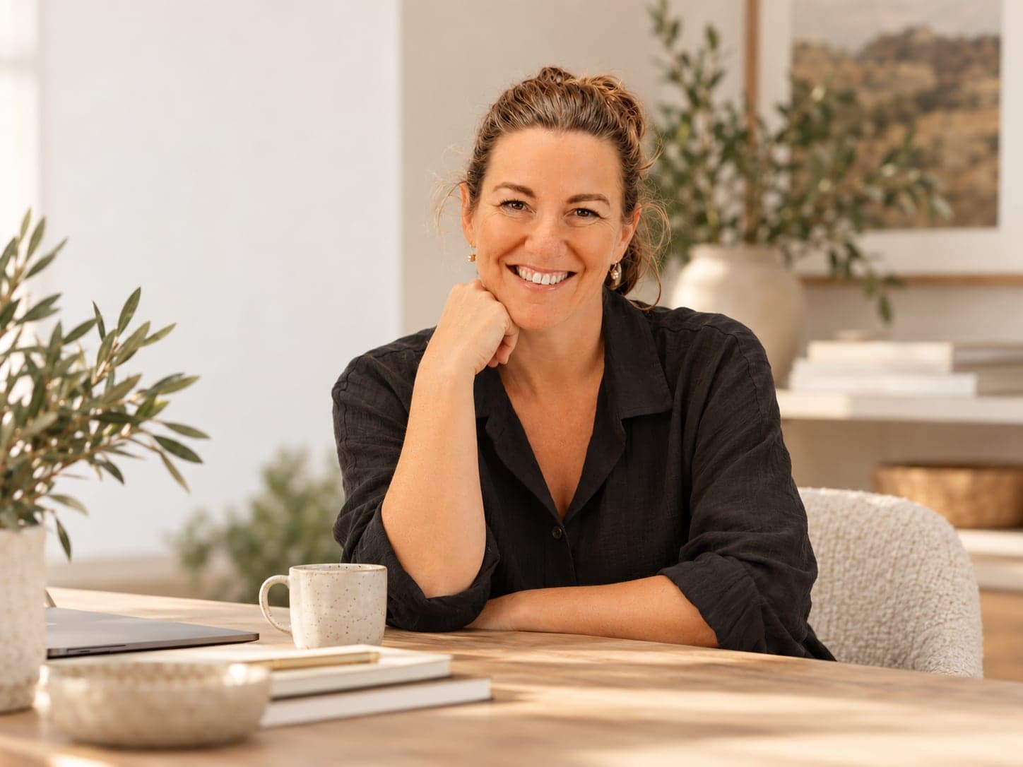 Kathryn Weekley smiling at her desk, chin resting on her hand
